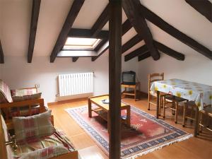 a living room with a bed and a table at Posada Rural La Capellanía in Celis