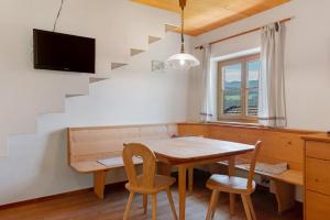 a dining room with a table and chairs and a staircase at Rielingerhof in Collalbo