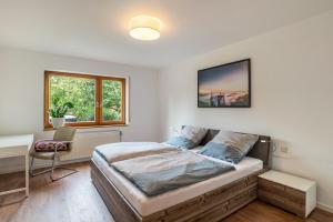 a bedroom with a bed and a desk and a window at Haus Gartenblick in Annweiler am Trifels