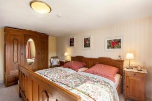 a bedroom with a large bed with two pink pillows at Ferienwohnung Prinzessinengarten in Jesberg