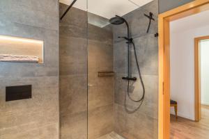 a shower with a glass door in a bathroom at Haus Gartenblick in Annweiler am Trifels +15 photos