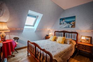 a bedroom with a bed with yellow pillows and a window at Courseulles Comme À La Maison in Courseulles-sur-Mer