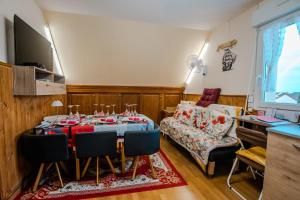 a living room with a table and a couch at Courseulles Comme À La Maison in Courseulles-sur-Mer