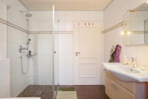 a bathroom with a sink and a shower at Haus Blaulichtfamilie in Opfenbach +15 photos