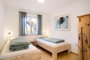 a bedroom with two beds and a window at Haus Blaulichtfamilie in Opfenbach