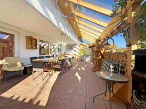 a patio with tables and chairs and a fence at Haus Blaulichtfamilie in Opfenbach