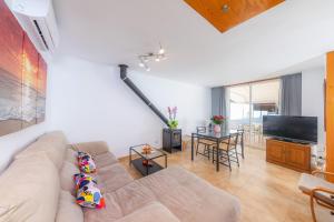 a living room with a couch and a television at Can Bennasar in Can Picafort