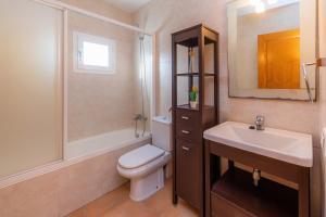 a bathroom with a white toilet and a sink at Can Bennasar in Can Picafort +22 photos