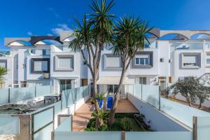 an apartment with palm trees on the balcony of a building at Can Bennasar in Can Picafort