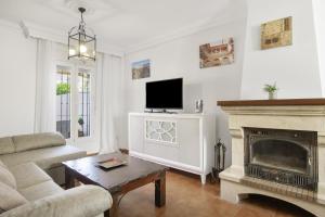 a living room with a fireplace and a tv at Casa Cherie con piscina privada in Ronda