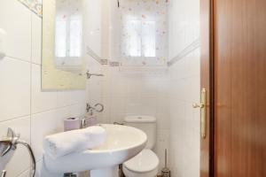 a white bathroom with a sink and a toilet at Casa Cherie con piscina privada in Ronda +16 photos