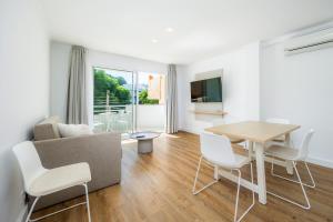 a living room with a couch and a table and chairs at Apartament Massanet 1a in Canyamel