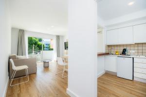 a kitchen and living room with white cabinets at Apartament Massanet 1a in Canyamel