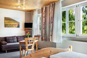 a living room with a bed and a couch at Wein- und Gästehaus Lutz in Iphofen