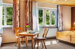 a dining room with a table and chairs and windows at Wein- und Gästehaus Lutz in Iphofen