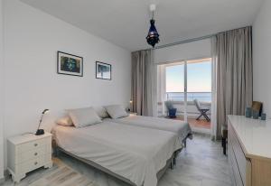 a bedroom with a bed and a view of the ocean at Apartment Boulevard 302 in Estepona +18 photos