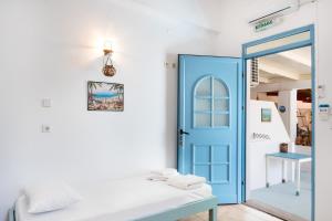 a room with a blue door and a bed at Beachfront Lampis Dolphin 2 in Skala