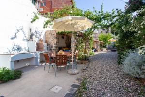 a patio with a table and an umbrella at Domo Bangone in Orosei