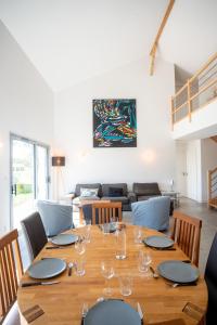 a dining room with a wooden table and chairs at Villa Surf and Golf in Messanges