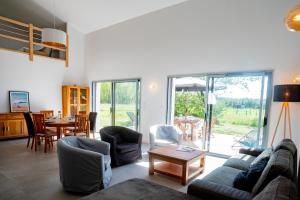 a living room with a couch and chairs and a table at Villa Surf and Golf in Messanges