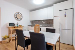 a kitchen with a white table and chairs and a white refrigerator at Complejo Colibri 13 in Cambrils