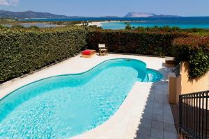 a blue swimming pool with a view of the ocean at Apartment Ida Isuledda 2 in San Teodoro