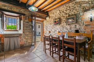 a dining room with a table and a brick wall at La Breval in Alles