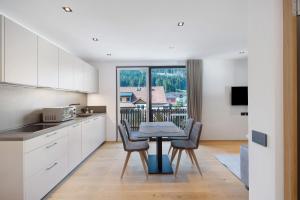 a kitchen with a table and chairs in a room at Premium App Hofer Marianna in Villabassa