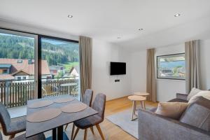 a living room with a couch and a table with chairs at Premium App Hofer Marianna in Villabassa