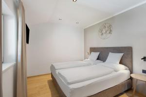 a bedroom with a white bed with white sheets at Premium App Hofer Marianna in Villabassa