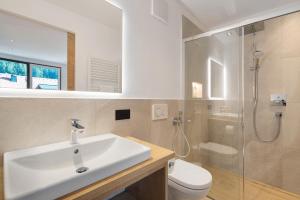 a bathroom with a sink and a shower and a toilet at Premium App Hofer Marianna in Villabassa +24 photos