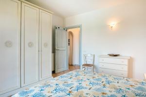 a bedroom with a bed and a dresser and a chair at Bia de Bados B5 in Olbia