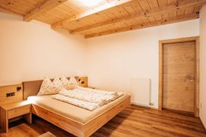 a bedroom with a bed and a wooden floor at Apartment Ida - Obermösslhof in Lana