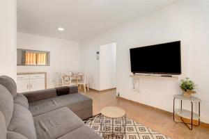 a living room with a couch and a flat screen tv at Casa Roberto in Candelaria