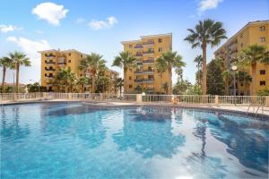 a large swimming pool with palm trees and buildings at Casa Roberto in Candelaria