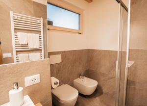 a bathroom with a toilet and a glass shower at Apartment Ida - Obermösslhof in Lana