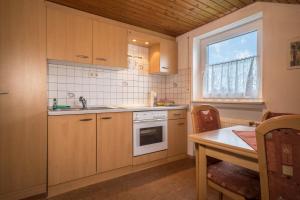 a kitchen with wooden cabinets and a table and a window at Ferienwohnung Steinhilber 1 in Eriskirch