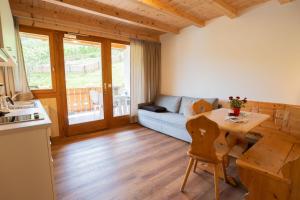 a living room with a table and a couch at Apartment Ida - Obermösslhof in Lana +20 photos
