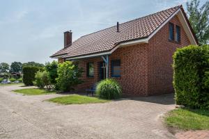 a brick house with a bench in front of it at Haus Hafenblick in Walchum