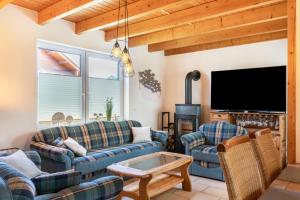 a living room with couches and a flat screen tv at Haus Hafenblick in Walchum
