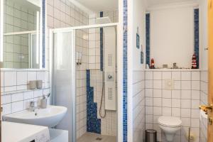 a white bathroom with a sink and a shower at Haus Hafenblick in Walchum +22 photos
