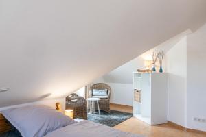 a bedroom with a bed and a chair at Haus Hafenblick in Walchum