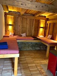 two beds in a room with wooden walls at Ferienhaus Hederle in Elzach