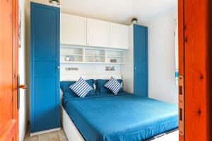 a bedroom with a blue bed with white cabinets at Bilocale Geranium Beach in San Teodoro