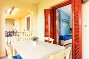 a table and chairs in a room with a balcony at Bilocale Geranium Beach in San Teodoro