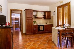 a kitchen with wooden cabinets and a table and a counter at Bilo Camelia in Marina di Grosseto