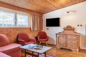 a living room with two chairs and a tv at Villa Soldanella in Ortisei