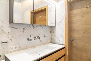 a bathroom with a white sink and a mirror at Ferienwohnung Elsa in Fliess +25 photos