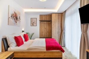 a bedroom with a large bed with red pillows at Ferienwohnung Elsa in Fliess