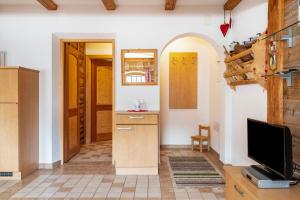 a living room with a tv and a kitchen at Thomasegg Hof Linde in Sarntal